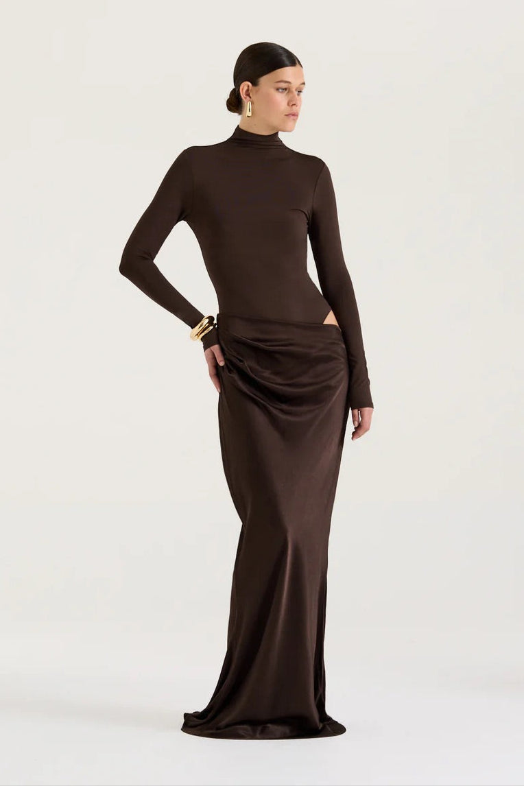 Woman wearing a brown long-sleeve dress against a white background